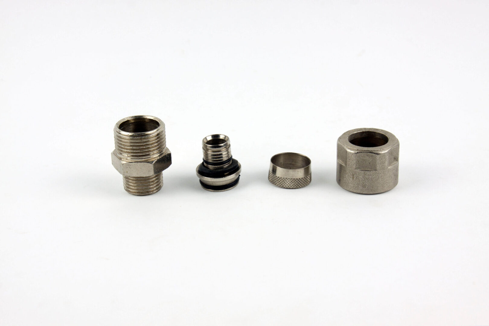 A set of stainless steel threaded fittings on a white background.