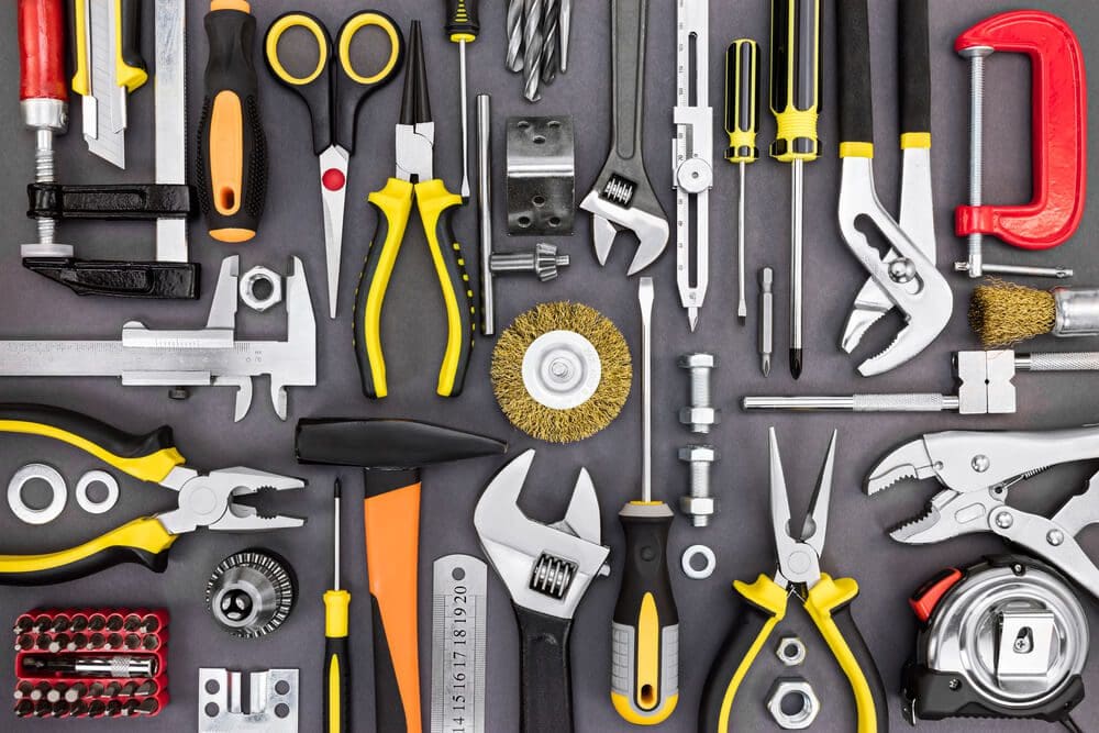 A variety of tools are arranged on a gray background.