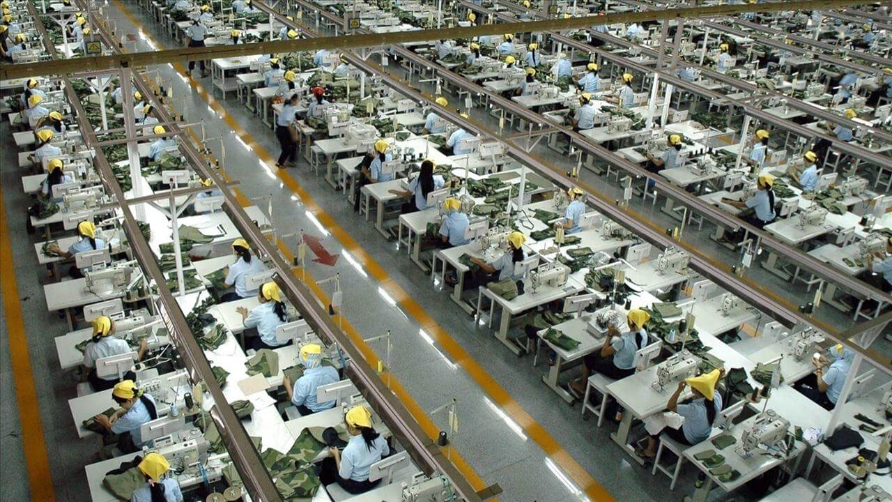 A factory with many people working at desks.
