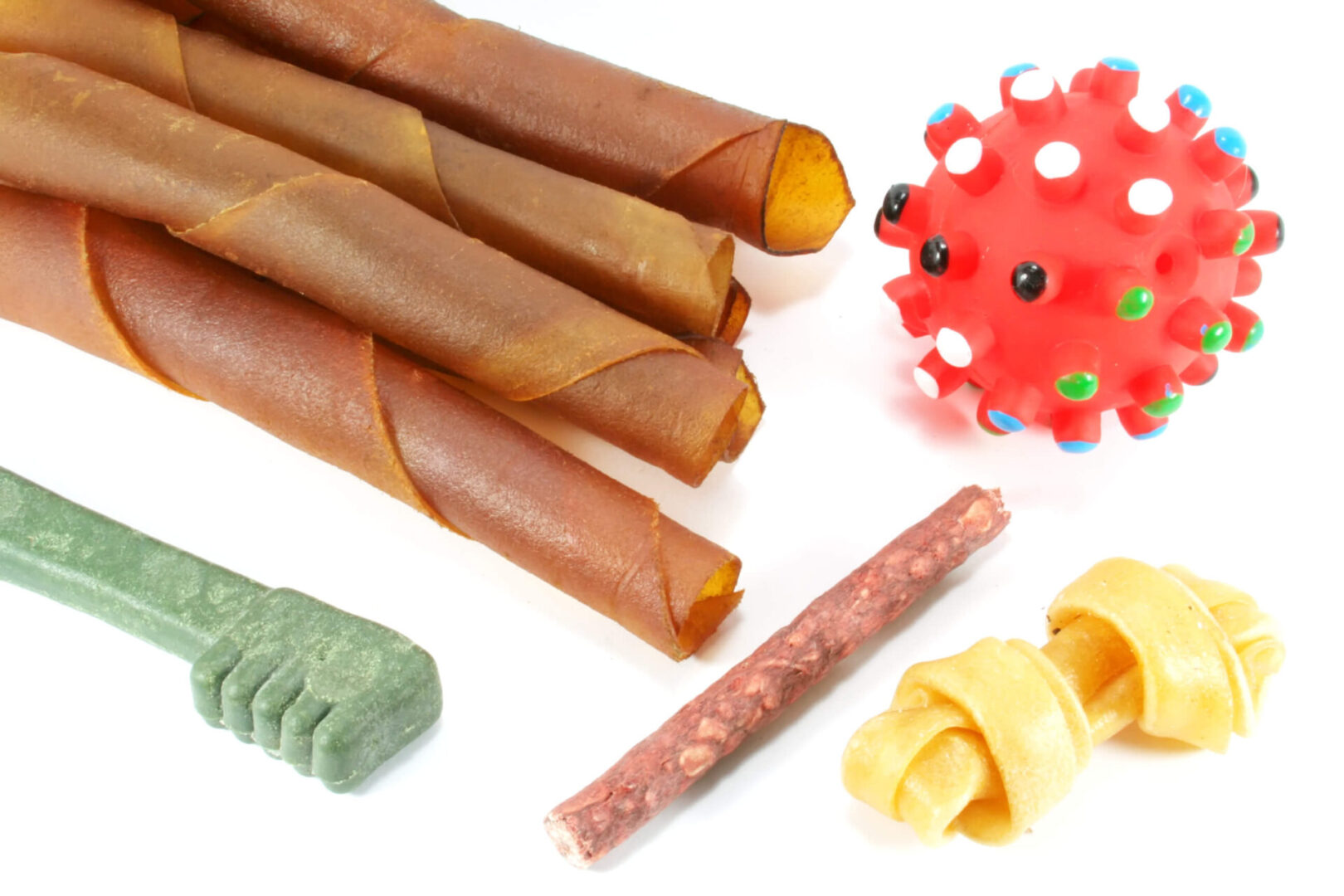 A variety of dog treats and toys on a white background.