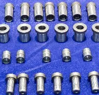 A set of stainless steel nuts and bolts on a blue background.