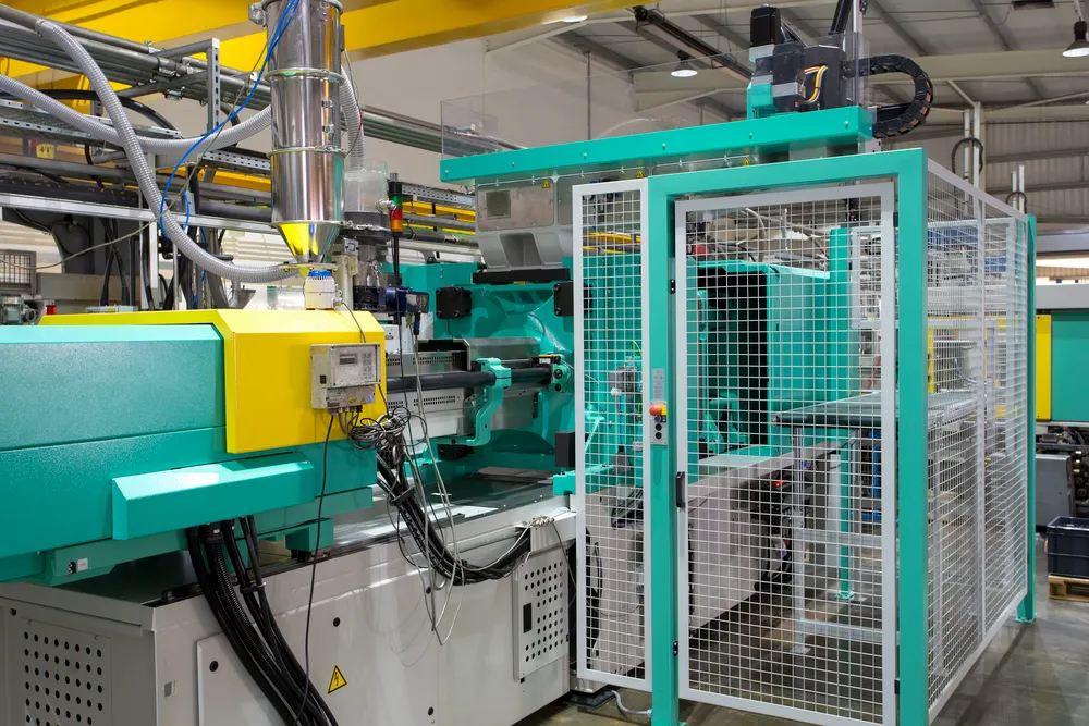 A green and yellow machine in a factory.