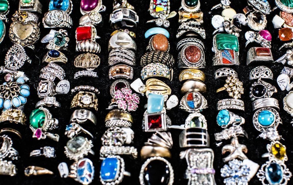 A variety of rings are displayed on a black background.